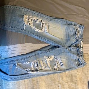 High Rise Relaxed Fit light blue jeans with rips in the legs.